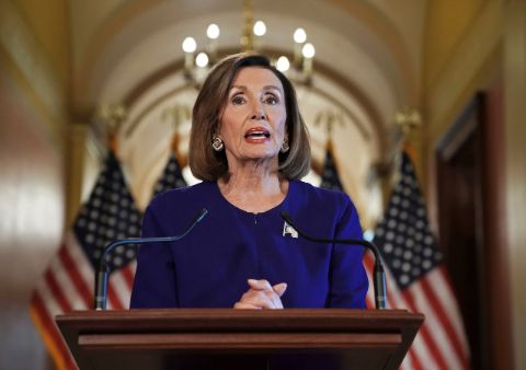 Nancy Pelosi in a blue dress giving a speech.